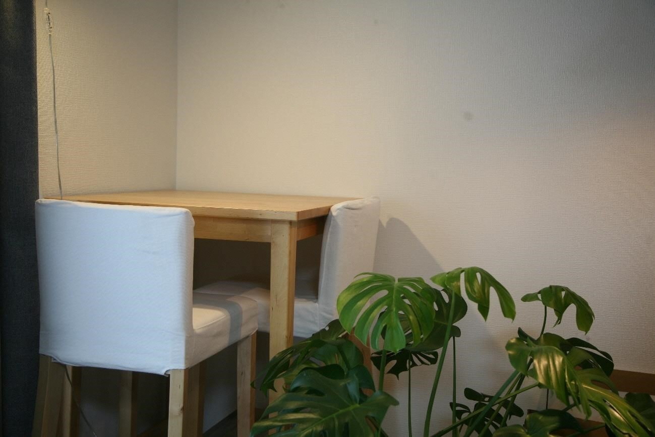 右に観葉植物左に正方形の机と2脚の椅子が置かれている三田市に移住して来た伊坂邦敏さん宅内部の写真