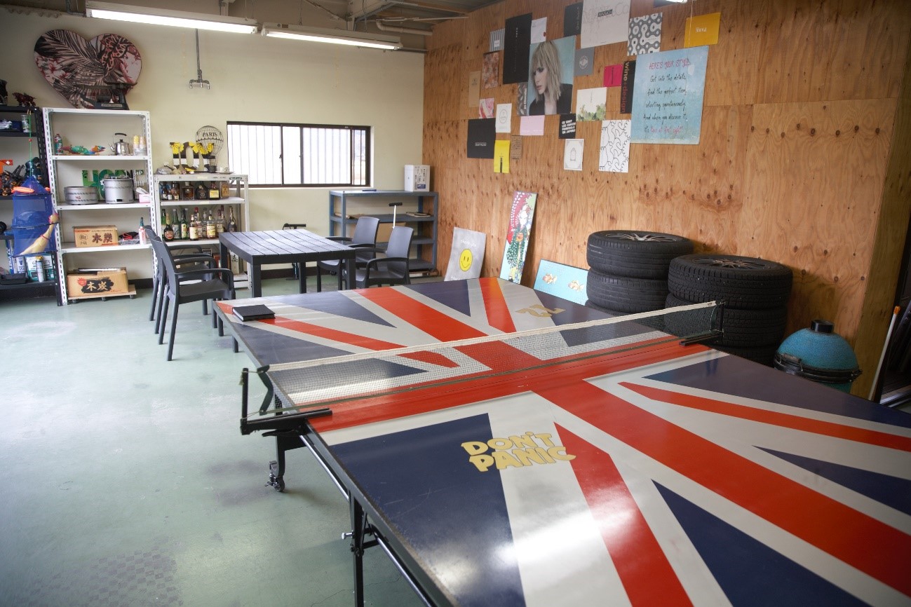 イギリス国旗がデザインされた卓球台の横に4人掛けテーブルがおかれた高橋さんの家の1階の写真
