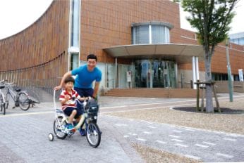二人乗り用の自転車に乗って楽しそうに走る今野 祐樹(こんの ゆうき）さんと息子の写真