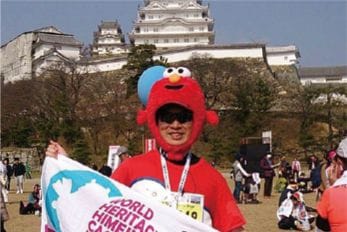 赤い着ぐるみをかぶってマラソン大会に参加する今野 祐樹(こんの ゆうき）さんの写真