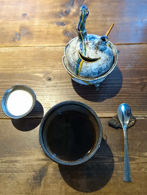 コーヒーを淹れたお茶碗とポットとミルクの写真