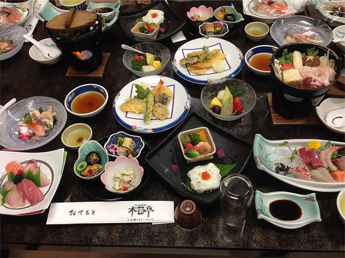 天ぷらやお刺身などの小皿がたくさん置かれている写真
