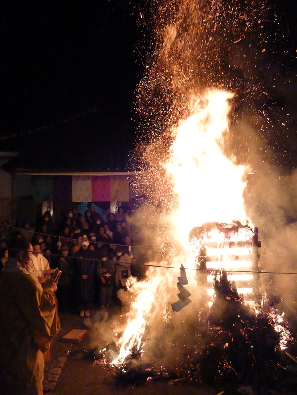 祭りで火を燃やし、それを見守っている多くの人々の写真