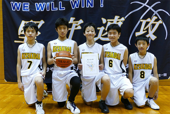 バスケットボールを持ち、白を基調としたユニフォームを着た男子小学生5人の写真