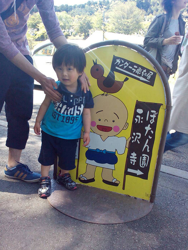 一休さんの看板とその傍に立つ男子児童の写真